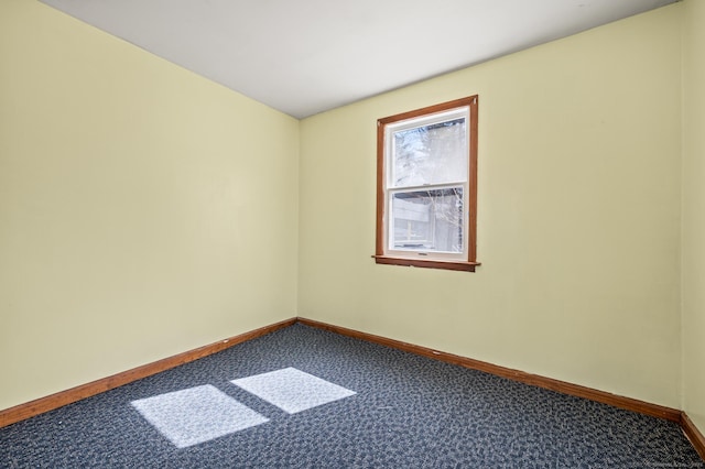 carpeted empty room featuring baseboards