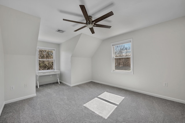 additional living space featuring a wealth of natural light, visible vents, carpet flooring, and a ceiling fan