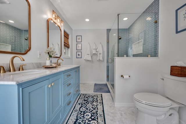 bathroom featuring a sink, toilet, a stall shower, and double vanity