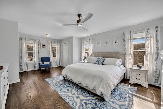 bedroom with multiple windows, wood finished floors, and baseboards