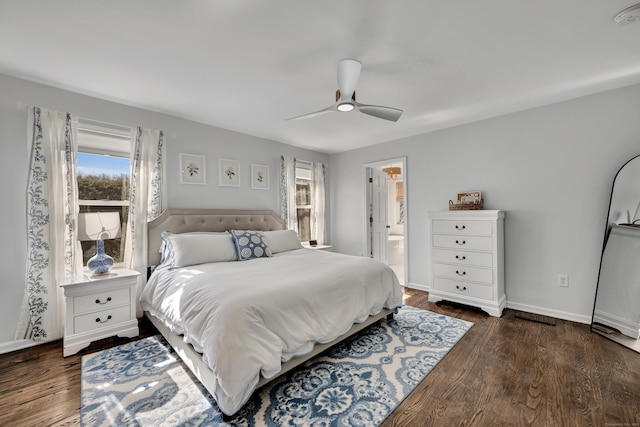 bedroom featuring a ceiling fan, wood finished floors, baseboards, and ensuite bathroom