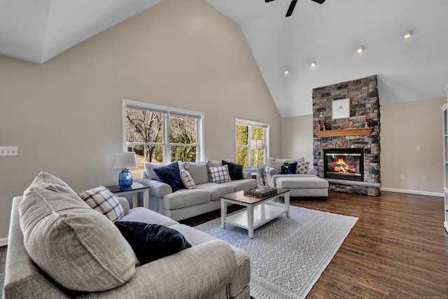 living room featuring baseboards, ceiling fan, a fireplace, high vaulted ceiling, and dark wood-style flooring