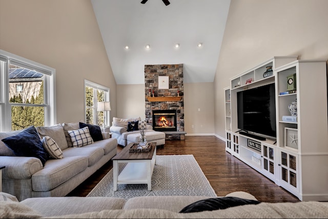 living area with a fireplace, high vaulted ceiling, baseboards, and wood finished floors