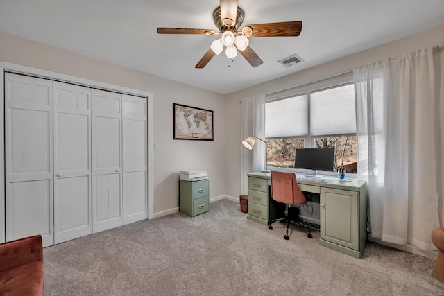 office featuring visible vents, light colored carpet, baseboards, and ceiling fan