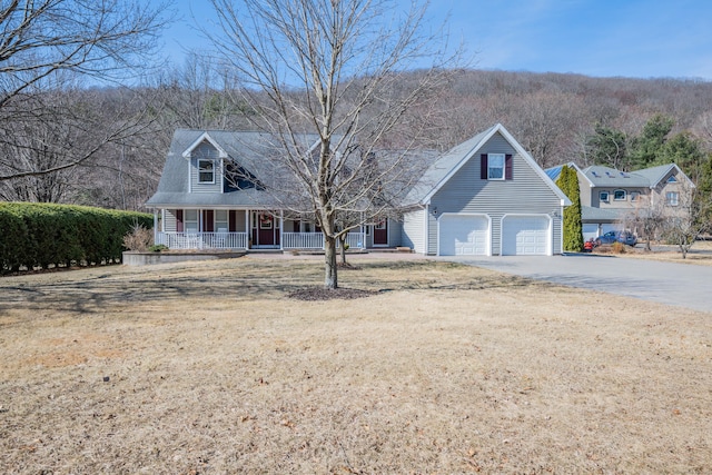 cape cod house featuring a garage, covered porch, and driveway