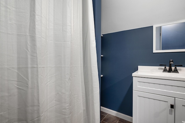 full bath with baseboards and vanity