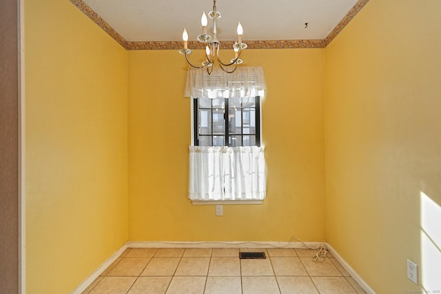 tiled spare room featuring visible vents, baseboards, and a chandelier