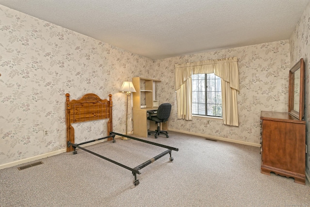 unfurnished bedroom featuring wallpapered walls, baseboards, visible vents, and a textured ceiling