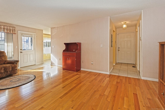 unfurnished living room featuring light wood finished floors and baseboards