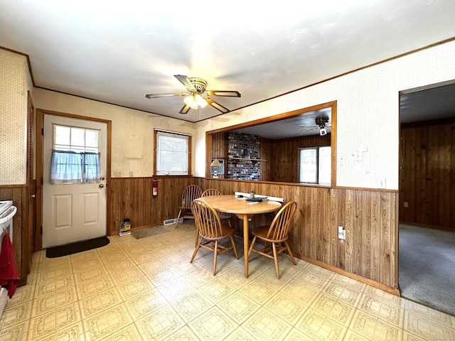 dining room with tile patterned floors, a ceiling fan, a wealth of natural light, and wainscoting