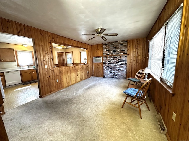 unfurnished room featuring wooden walls, light colored carpet, visible vents, and ceiling fan