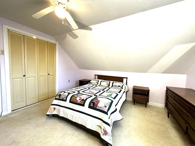 bedroom featuring baseboards, ceiling fan, vaulted ceiling, light carpet, and a closet