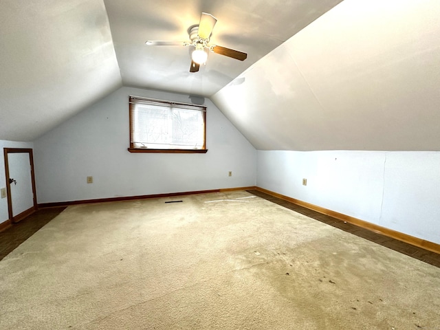 additional living space featuring carpet floors, baseboards, a ceiling fan, and vaulted ceiling