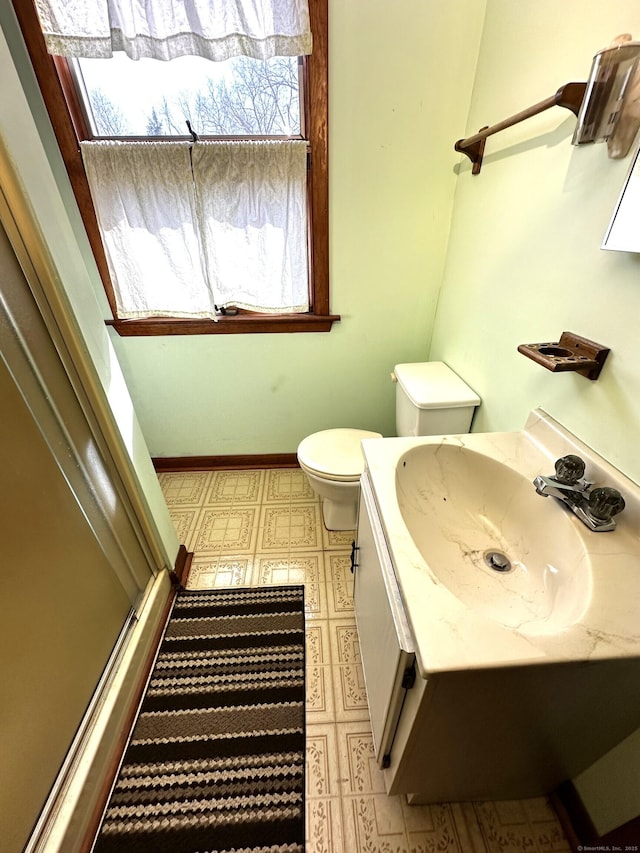 bathroom featuring vanity, baseboards, a stall shower, tile patterned floors, and toilet