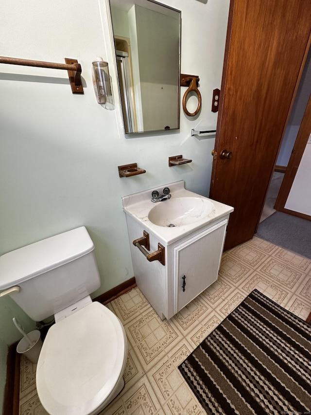 bathroom featuring tile patterned floors, baseboards, toilet, and vanity