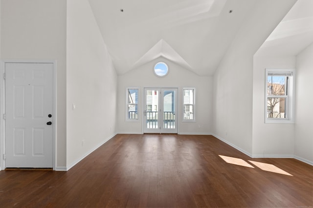 unfurnished living room with french doors, baseboards, dark wood-type flooring, and lofted ceiling