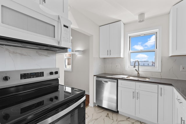 kitchen featuring backsplash, marble finish floor, appliances with stainless steel finishes, and a sink