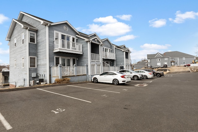 exterior space with central air condition unit, uncovered parking, and a residential view