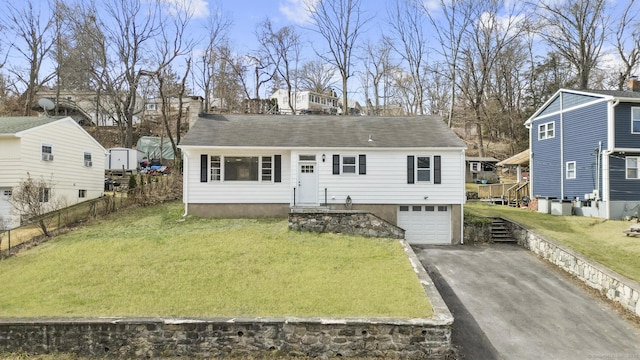 view of front of house with a garage, fence, a front yard, and aphalt driveway