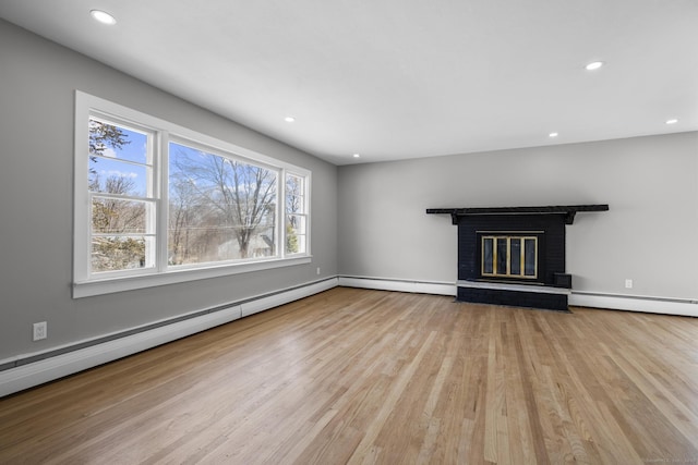 unfurnished living room with recessed lighting, a fireplace, a baseboard heating unit, and wood finished floors