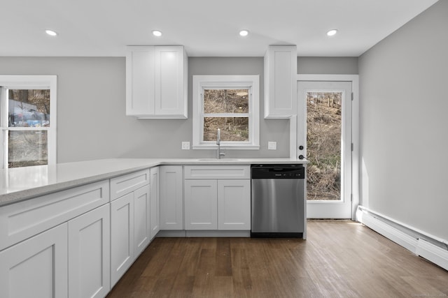 kitchen with white cabinetry, a sink, dark wood-type flooring, stainless steel dishwasher, and baseboard heating