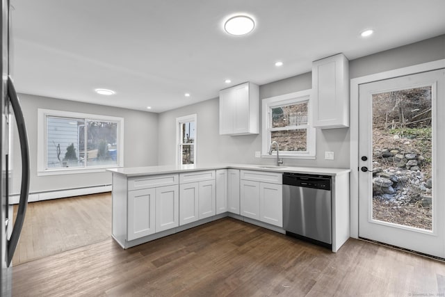 kitchen with a baseboard heating unit, dishwasher, a peninsula, white cabinetry, and a sink