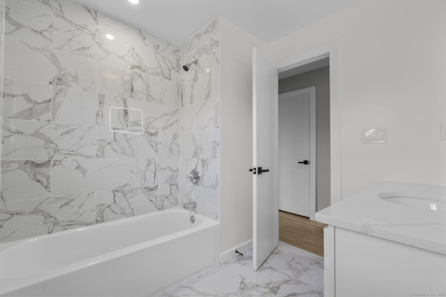 full bathroom featuring marble finish floor, vanity, and shower / bathtub combination