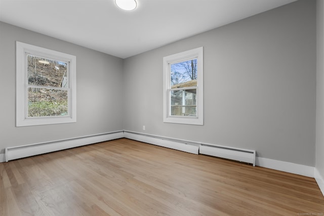 spare room with a healthy amount of sunlight, baseboards, and light wood finished floors