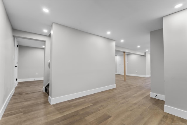 empty room with recessed lighting, baseboards, and wood finished floors