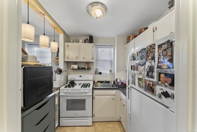 kitchen featuring hanging light fixtures, white appliances, dark countertops, and a sink