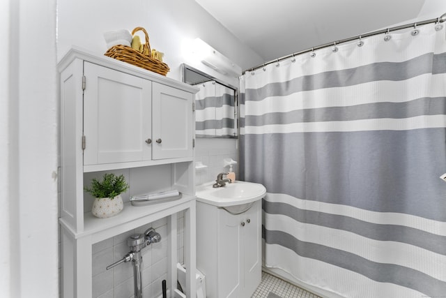 bathroom featuring vanity, tile walls, and curtained shower