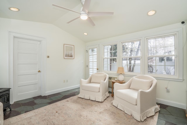 sitting room featuring recessed lighting, baseboards, a wood stove, and vaulted ceiling