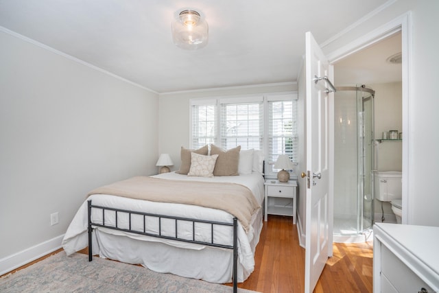 bedroom with crown molding, wood finished floors, and baseboards