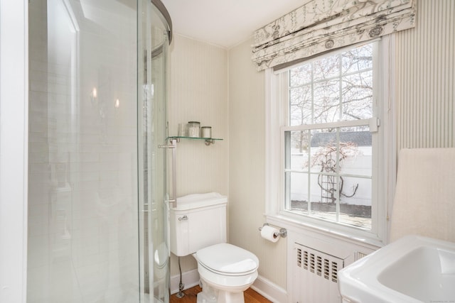 full bath with a shower stall, radiator, toilet, and baseboards