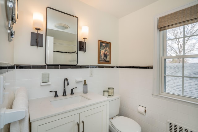 bathroom with toilet, tile walls, radiator, and vanity