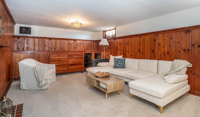 carpeted living room with wood walls