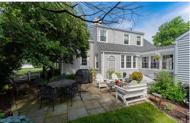 back of property featuring a patio, fence, roof with shingles, outdoor dining area, and a chimney