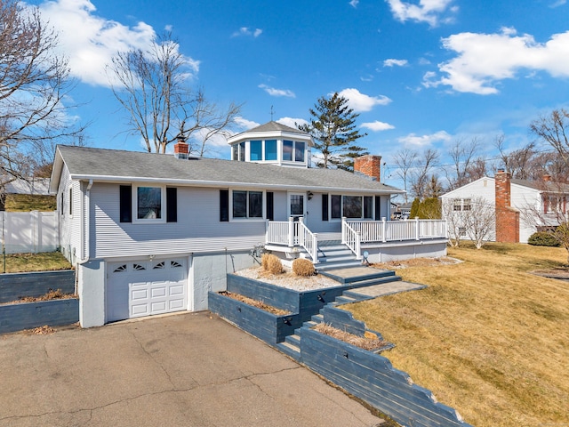 view of front of home with driveway, an attached garage, a shingled roof, a chimney, and a front lawn