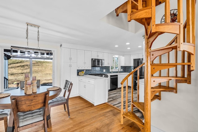 kitchen with white cabinetry, refrigerator, dishwasher, stainless steel microwave, and tasteful backsplash