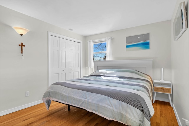 bedroom featuring a closet, baseboards, and wood finished floors