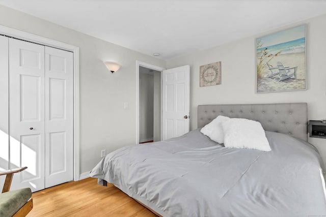 bedroom featuring wood finished floors, a closet, and baseboards