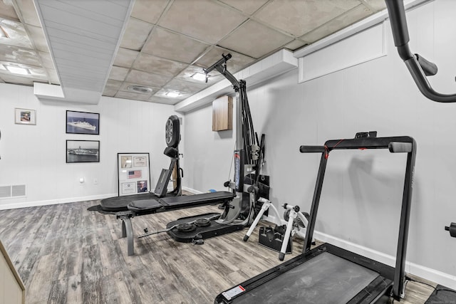 exercise room with visible vents, baseboards, and wood finished floors