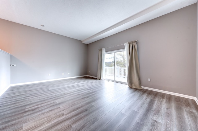 spare room featuring wood finished floors and baseboards