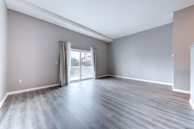 unfurnished room with baseboards and wood finished floors