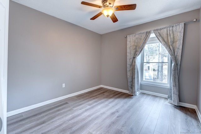 spare room featuring a ceiling fan, baseboards, and wood finished floors