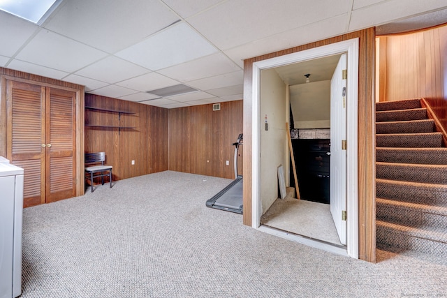 interior space featuring wood walls, stairs, carpet, and a paneled ceiling