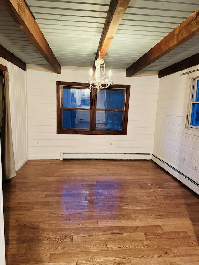 empty room with beamed ceiling, wood finished floors, wood walls, and a chandelier