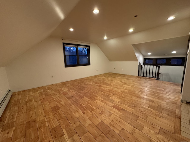 additional living space with recessed lighting, a baseboard heating unit, lofted ceiling, and wood finished floors