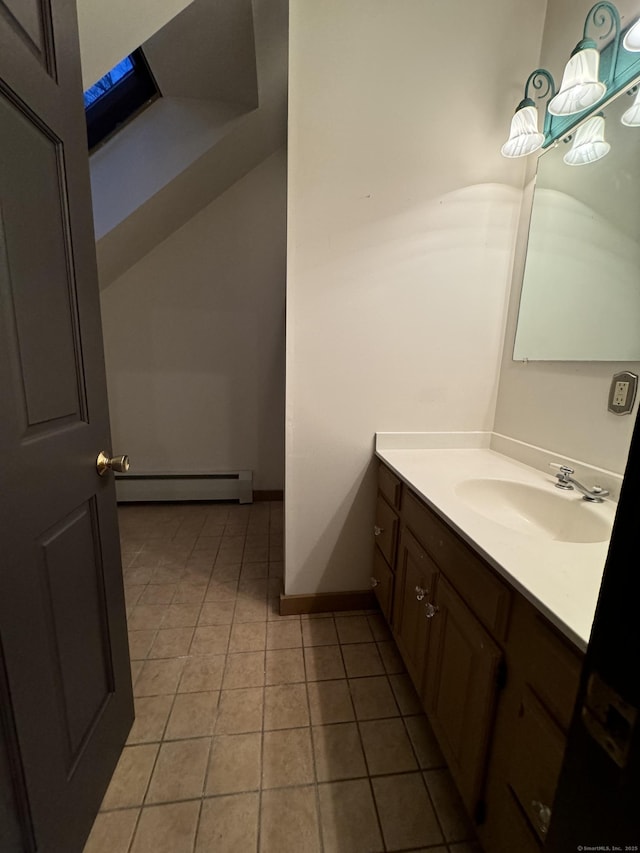 bathroom with tile patterned flooring, vanity, a baseboard heating unit, and baseboards