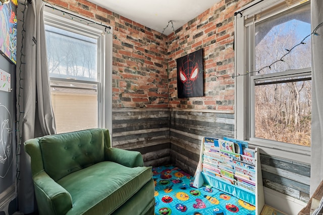 living area featuring brick wall